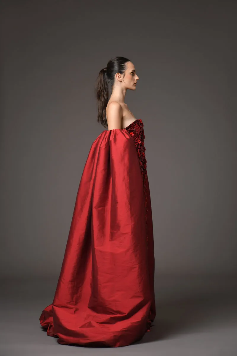 A futuristic red dress adorned with intricate floral patterns embroidered with mirror plexiglass, featuring detachable silk taffeta sleeves/cape