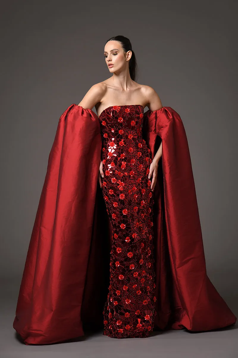 A futuristic red dress adorned with intricate floral patterns embroidered with mirror plexiglass, featuring detachable silk taffeta sleeves/cape